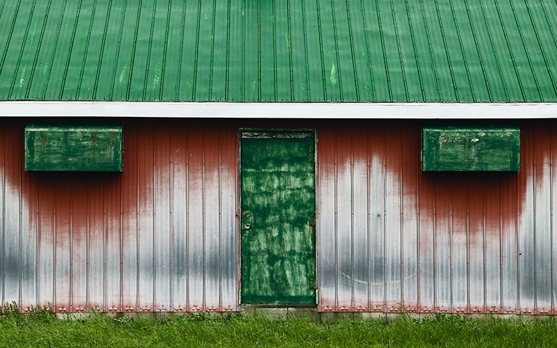 Metal barn with green roof and door