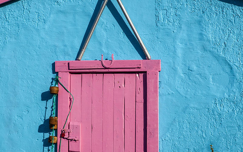 Crossed oars against blue and pink shed